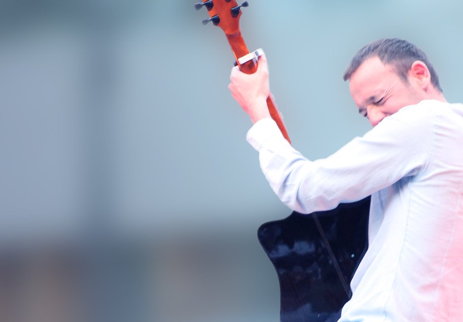 Cédric Talmon serre sa guitare contre lui en grimaçant de plaisir