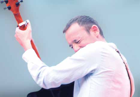 Cédric Talmon serre sa guitare contre lui en grimaçant de plaisir
